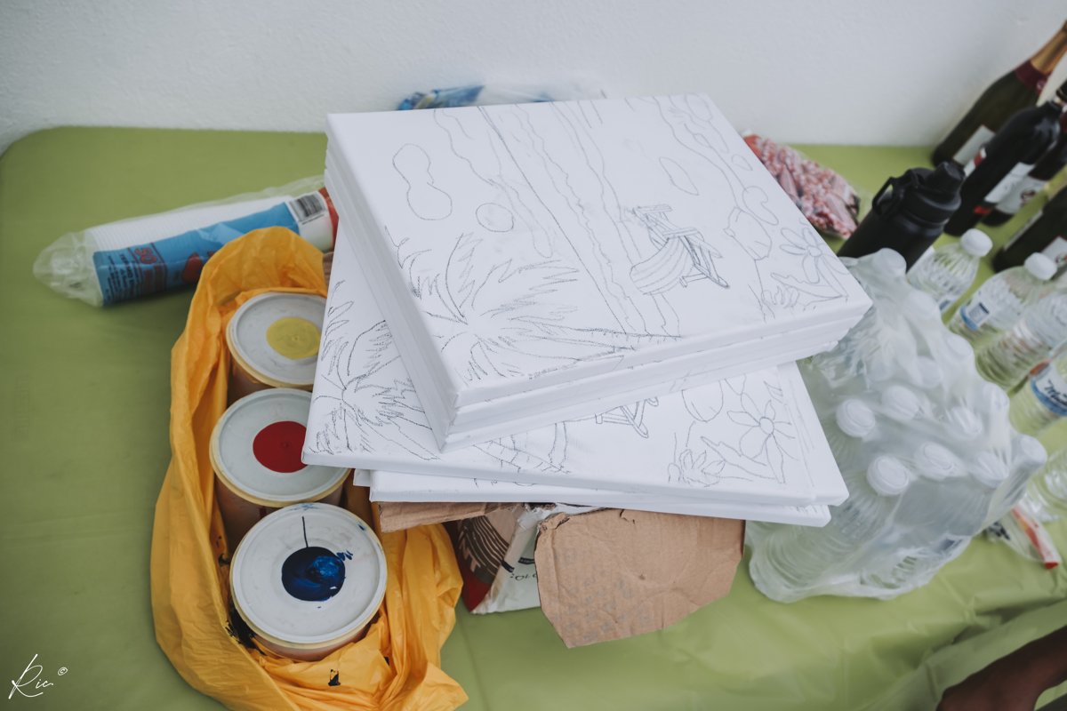 Blank outlined canvases wait beside paints and supplies.