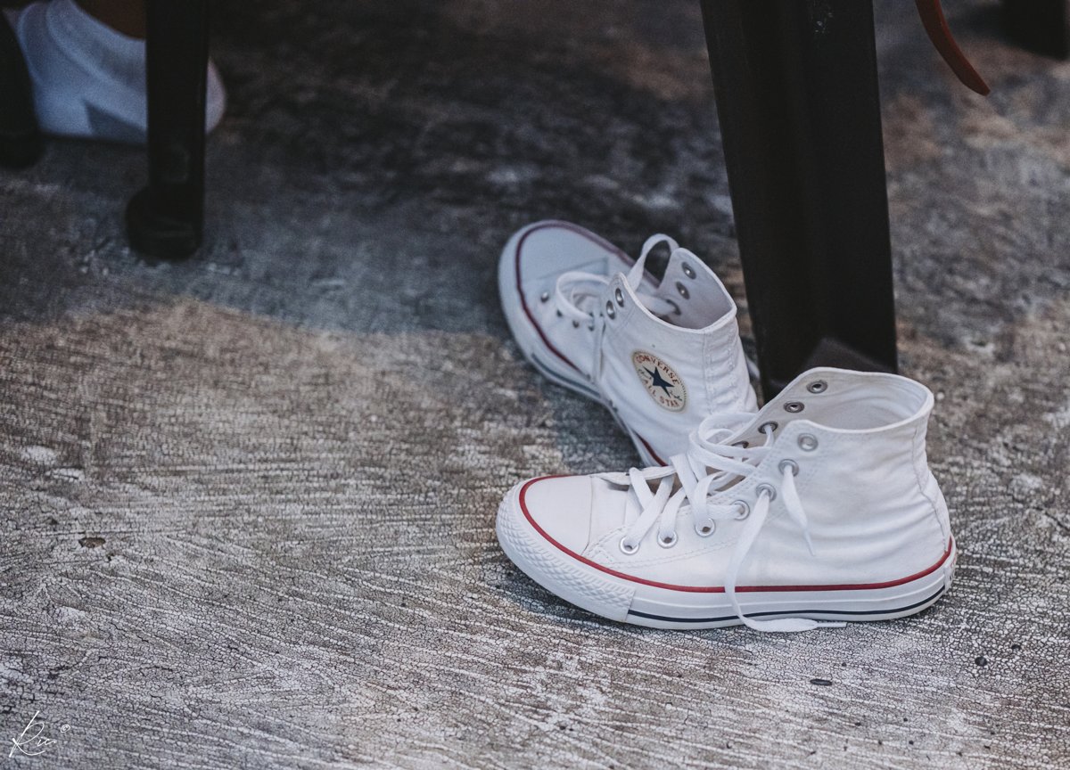 White high-top sneakers sit beneath the furniture.