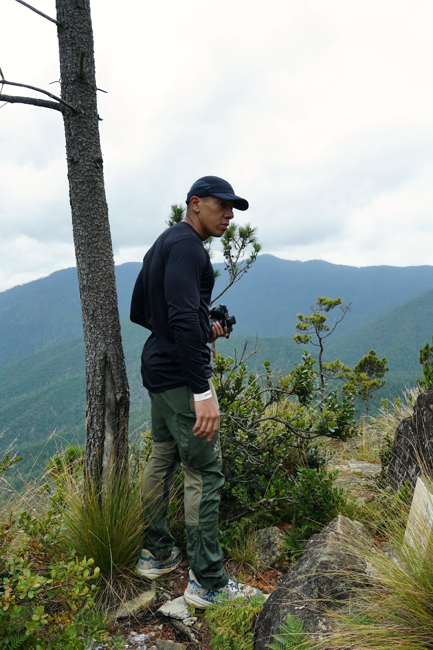 Ricardo on a mountain trail, holding his camera