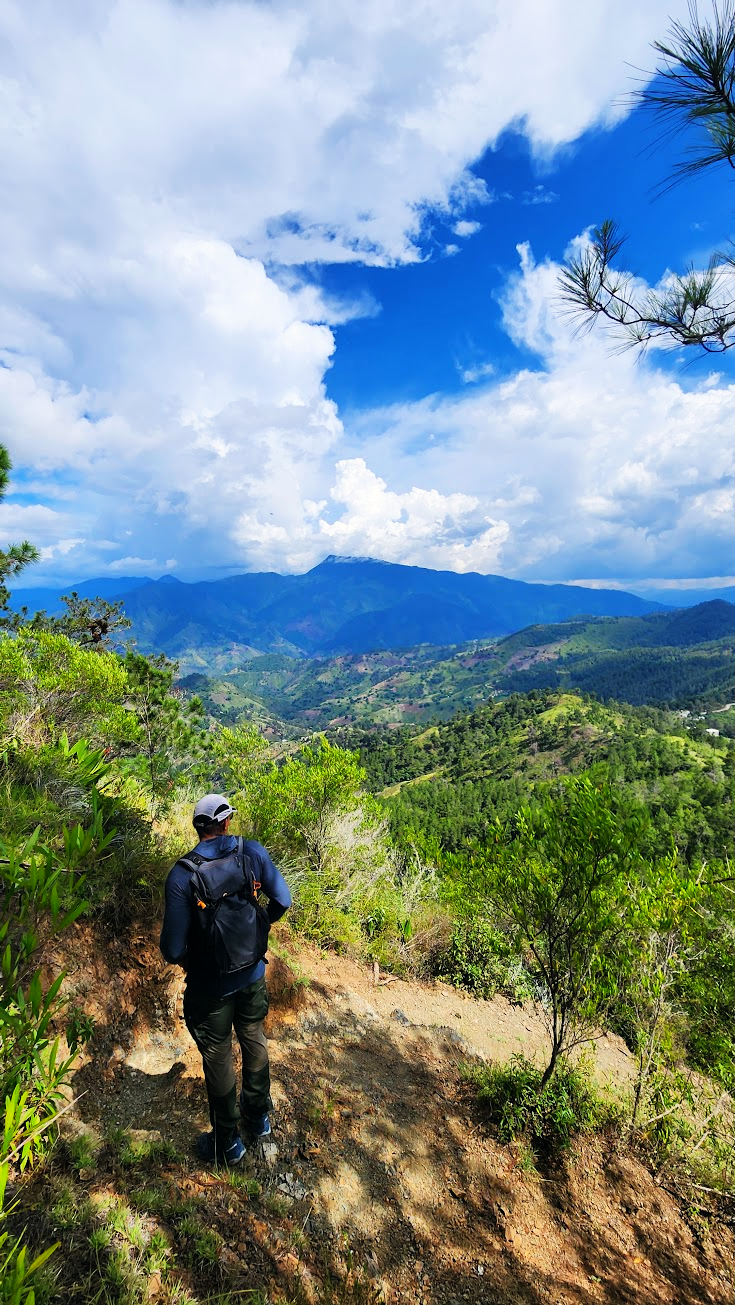 A mountain trail opening onto a green valley