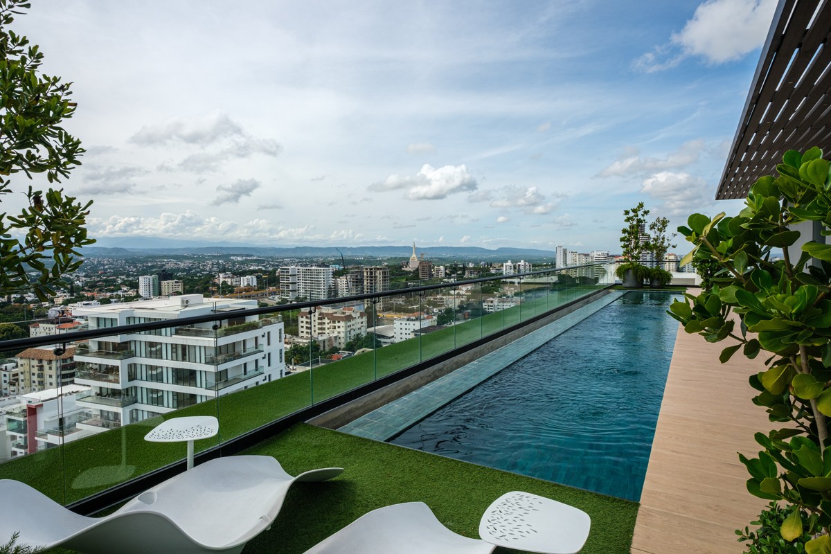A slim rooftop lap pool draws a line through the city panorama.